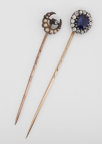 A late Victorian yellow metal, blue paste and diamond cluster set stick pin, 68mm, together with a 15ct, diamond and seed pearl set crescent stick pin. Condition - poor to fair